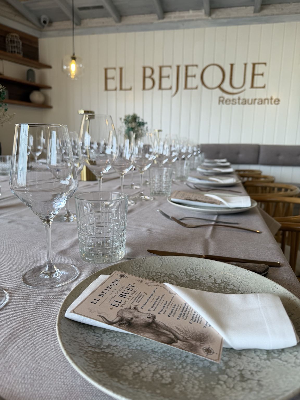 Mesa larga del Privé montada con copas, vajilla y menú del Club Bejeque
